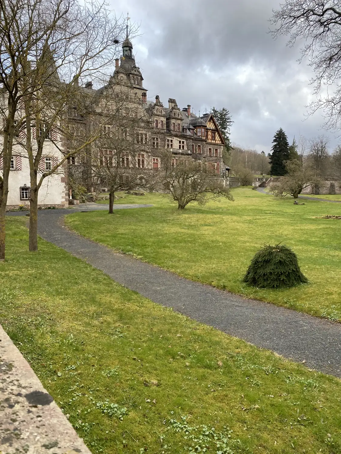 Blick über die Parkwiese vom älteren Bau zum Historismusflügel von Schloss Ramholz