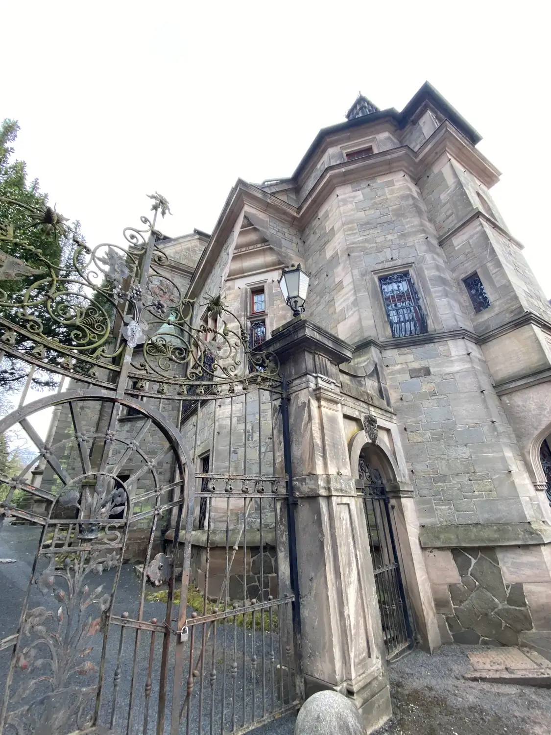 Sandsteinpfeiler mit Laterne und ein Pavillonbau mit geschmiedeten Fenstergittern in Ramholz